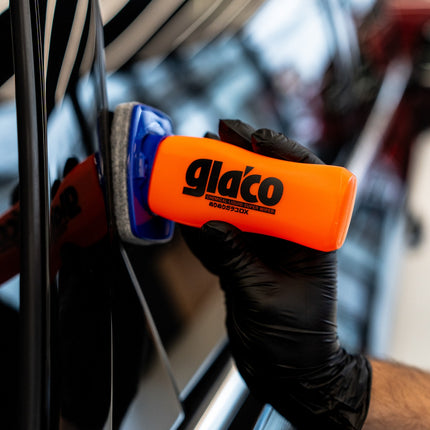 Aplikační lahvička Glaco DX v oranžovém provedení s modrou podložkou na skle